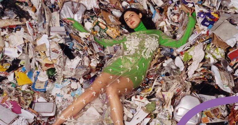 Woman laying in a pile of rubbish to illustrate today's overconsumption
