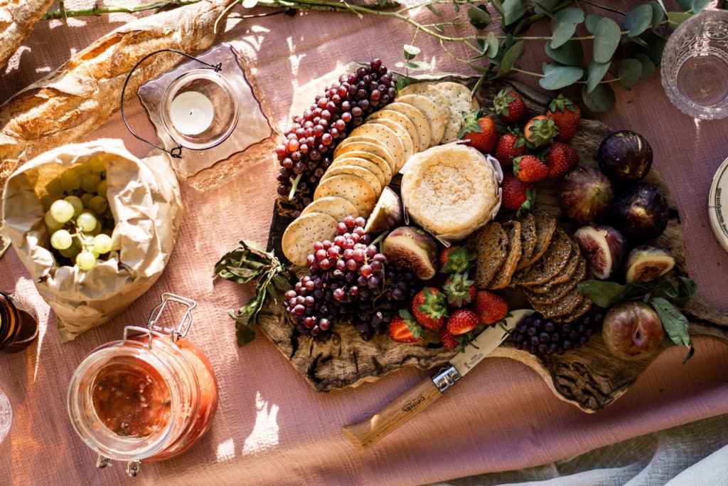 grazing platter with grapes, figs, strawberries, camembert cheese and crackers