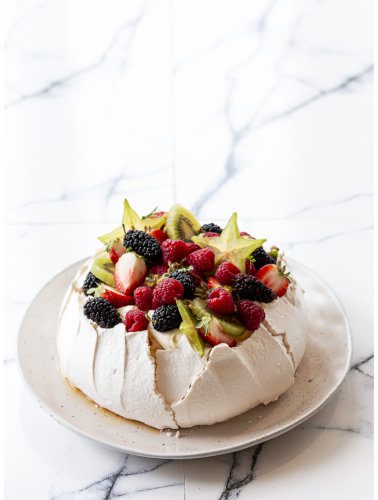 Traditional pavlova with strawberries, blackberries, raspberries, kiwis and starfruits christmas