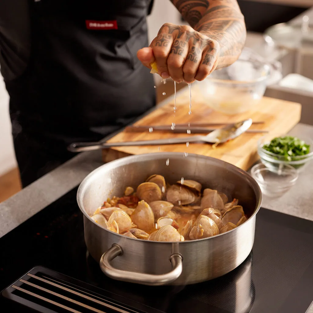 Michael Meredith cooking Cloudy Bay clams using Miele induction cooktop