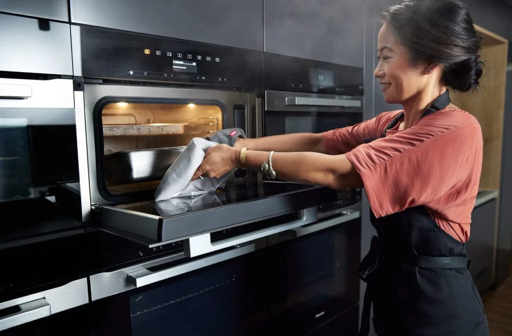 Palisa taking a dish out of a Miele steam oven
